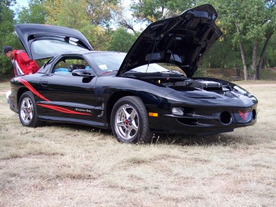 1972 Ford Ranchero - Black Pontiac Firebird with red racing stripes, hood and trunk open.