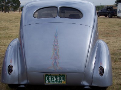 1972 Ford Ranchero - A silver custom hot rod with elaborate pinstriping is parked outdoors, with another vehicle visible in the background.