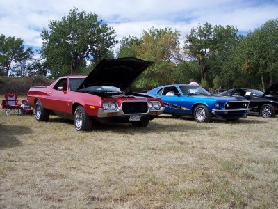 1972 Ford Ranchero - A red 1972 Ford Ranchero is displayed with its hood open at a car show, alongside other vehicles.