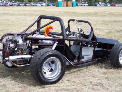 1972 Ford Ranchero - A custom dune buggy with a roll cage and exposed engine is parked on a grassy field.