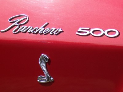 1972 Ford Ranchero - Chrome emblems on a red vehicle indicate 'Ranchero 500' and a Cobra snake.