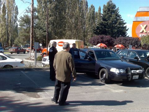 1999 Ford Crown Victoria - A dark 1999 Ford Crown Victoria police car is parked with its door open, alongside another vehicle.