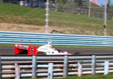1979 Ford F-150 - A race car with the number 6 and Marlboro livery speeds along the track.