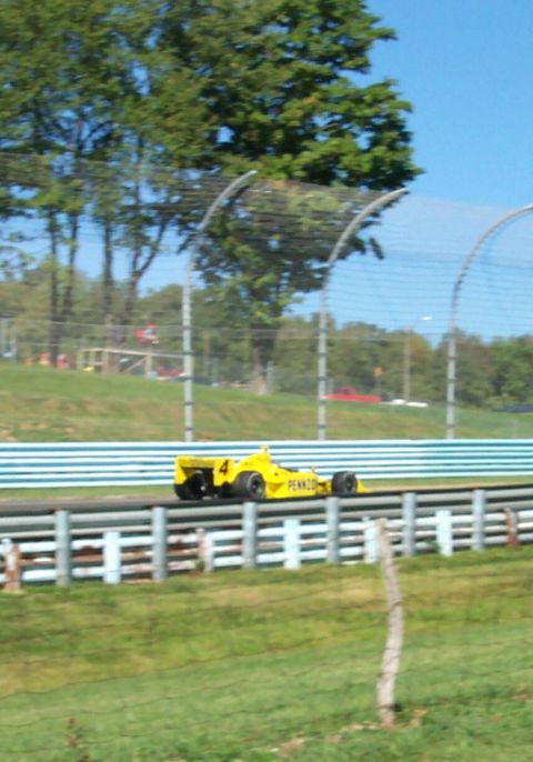 1979 Ford F-150 - A yellow race car, identified by the number 4 and Pennzoil sponsorship, speeds along a track.