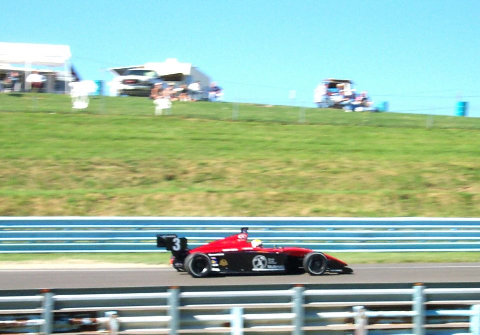 Open-wheel race car with number 3 on the rear wing, on a track