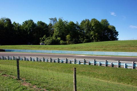1979 Ford F-150 - A sunny day at the racetrack with two vehicles visible on the adjacent grassy incline.