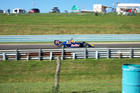 1979 Ford F-150 - Race car with number 51 and Red Bull livery speeds down the track.