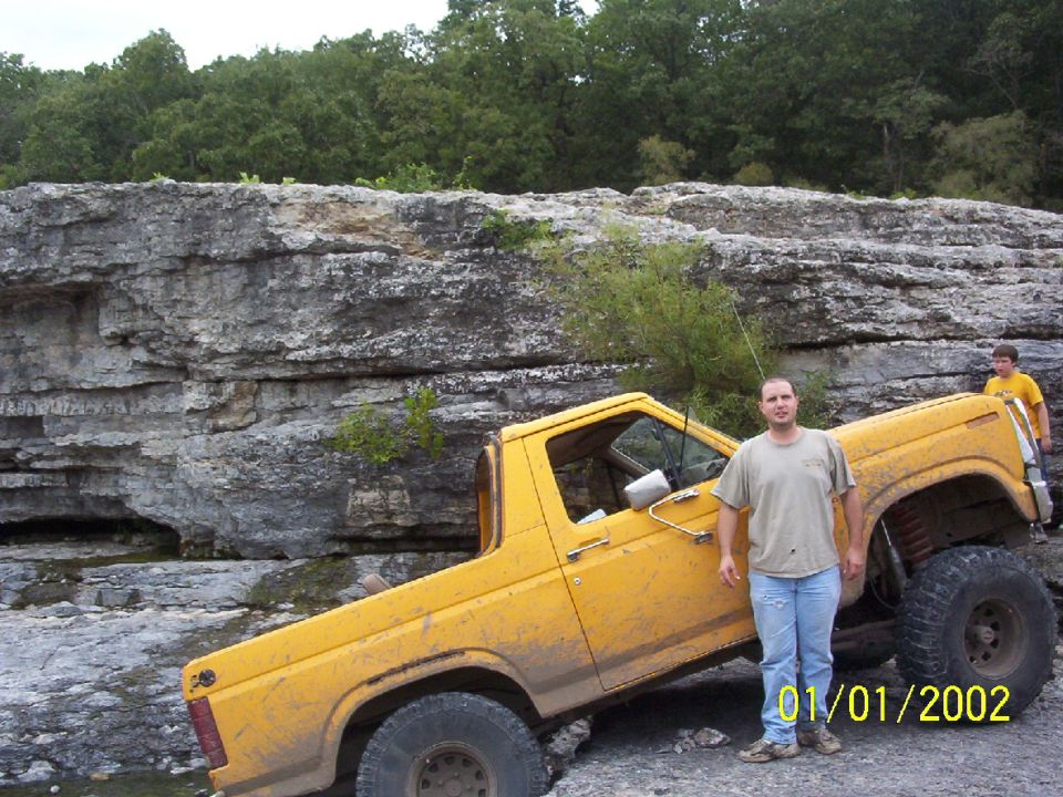 Yellow off-road SUV with lifted suspension parked on rocks