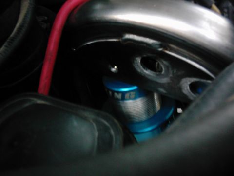 1978 Ford Bronco - Close-up of a blue coilover shock absorber with visible text on its body.