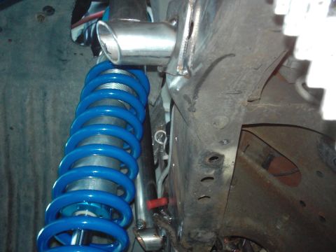 1978 Ford Bronco - Close-up view of a blue coilover suspension component attached to a vehicle's frame.