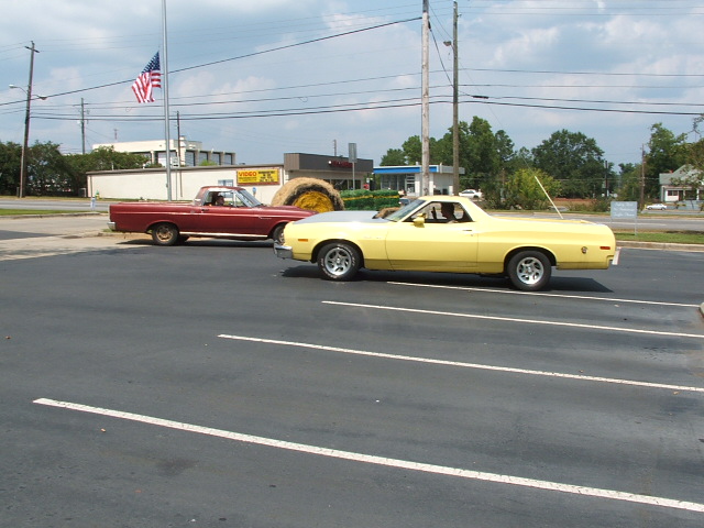 Yellow 1972 Ford Ranchero parked next to a red Ford Ranchero