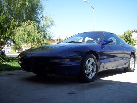 1995 Ford Probe - A blue 1995 Ford Probe is parked outside on a sunny day.