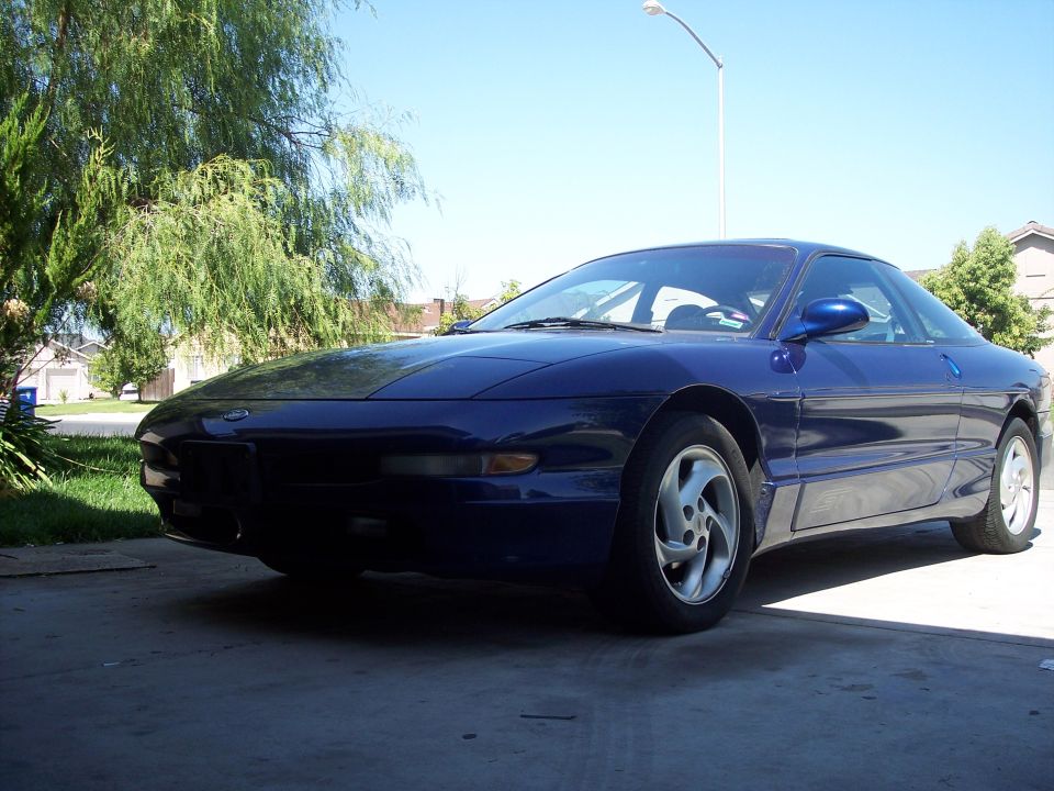 Blue 1995 Ford Probe coupe parked on concrete driveway, front 3/4 view