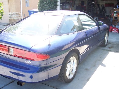 1995 Ford Probe - A blue 1995 Ford Probe is parked in a driveway, showing its rear 3/4 profile.