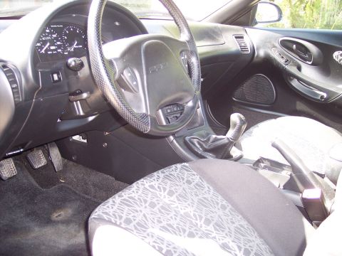 1995 Ford Probe - The interior of a 1995 Ford Probe is visible, including the driver's side controls and seats.