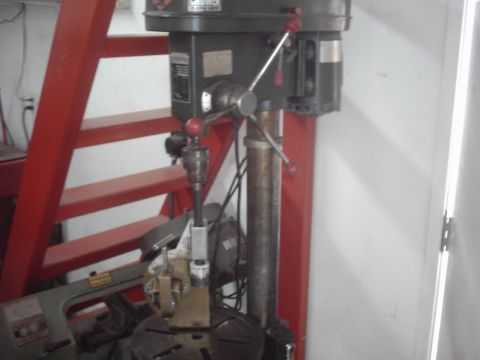 1978 Ford Bronco - A drill press is shown in a workshop setting, with a red ladder visible behind it.