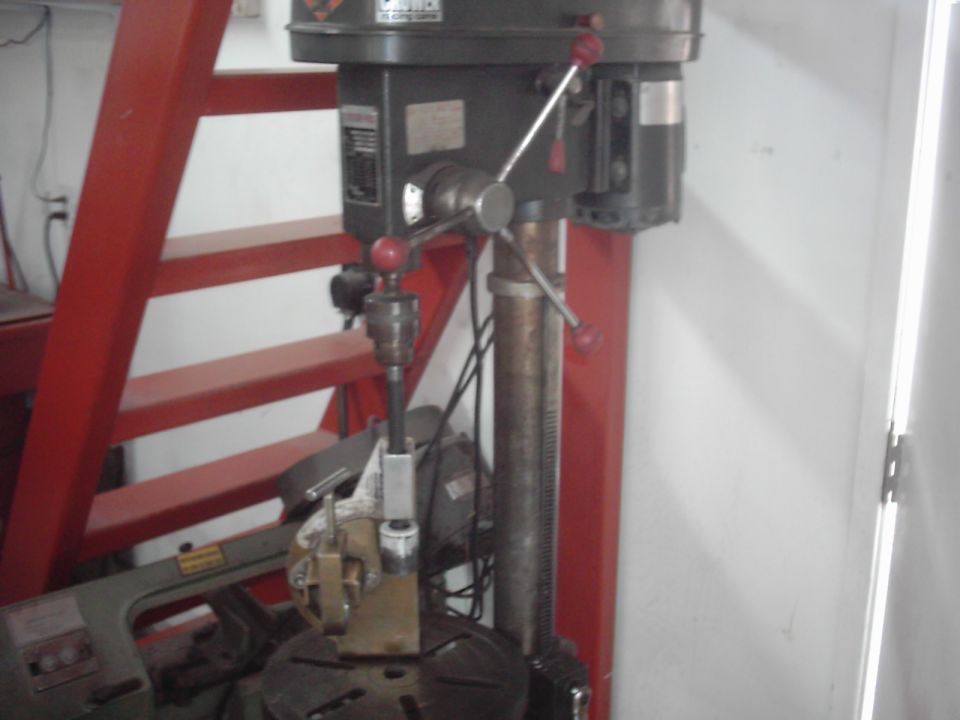 Drill press with red ladder in background