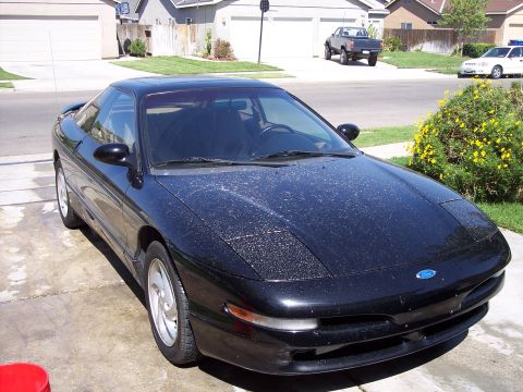 1995 Ford Probe - A black Ford Probe is parked in a suburban driveway.