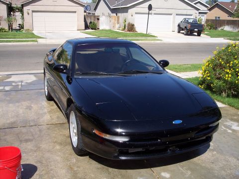 1995 Ford Probe - A black 1995 Ford Probe is parked in a driveway on a sunny day.