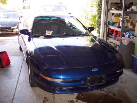 1995 Ford Probe - A blue 1995 Ford Probe is parked in a garage with another vehicle behind it.