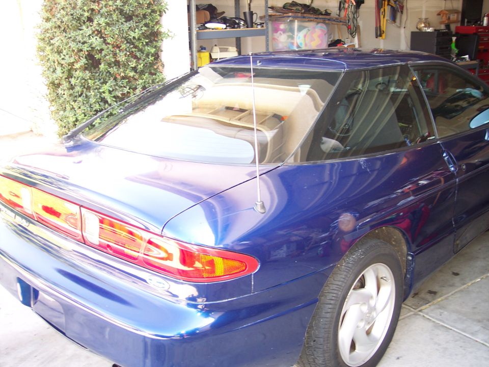 Blue 1995 Ford Probe coupe, rear quarter view, parked in a garage