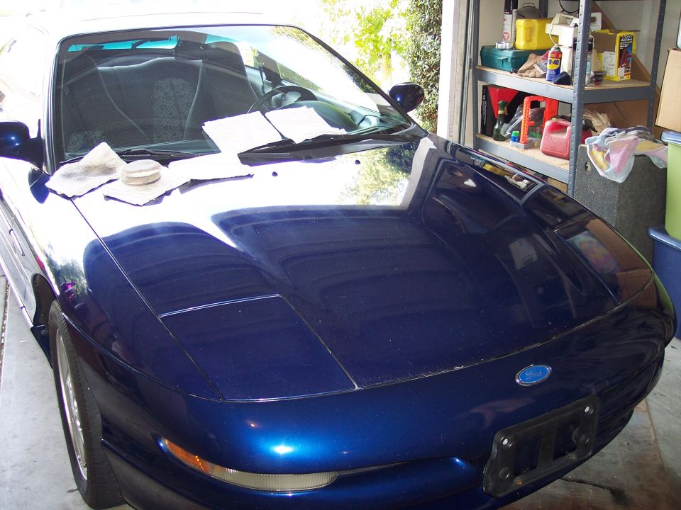 Blue 1995 Ford Probe hood with papers on it