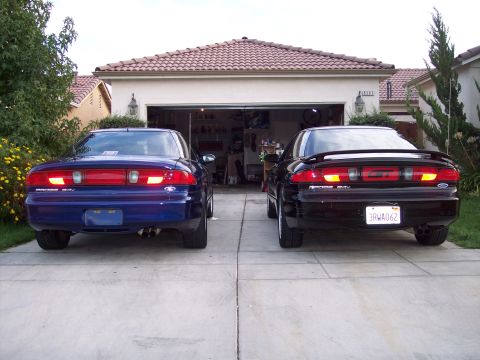 1995 Ford Probe - Two 1995 Ford Probes are parked in a driveway in front of a suburban garage.