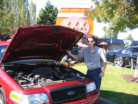 1999 Ford Crown Victoria - A red 1998 Ford Crown Victoria is displayed with its hood open, revealing the engine compartment.