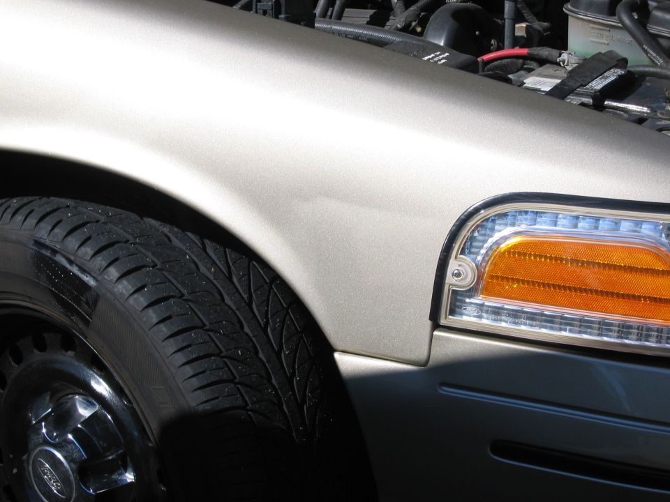 Front fender, tire, and headlight of a 1999 Ford Crown Victoria
