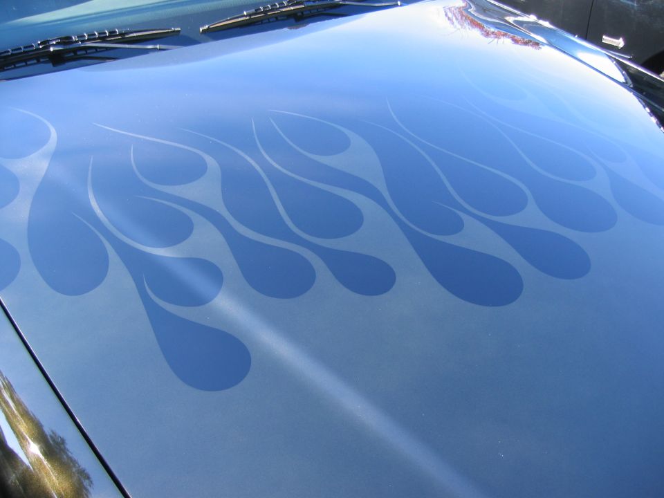 Blue car hood with light blue flame graphics and windshield wipers visible