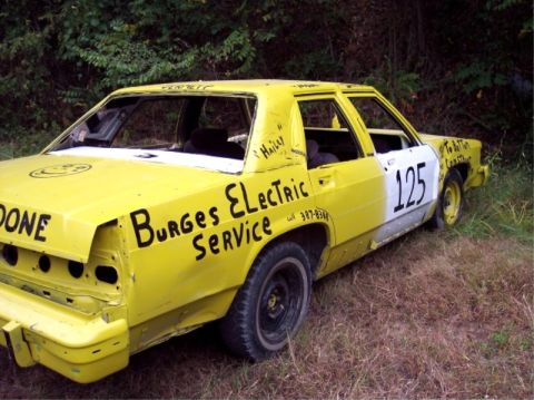 1987 Mercury Grand Marquis - This 1987 Mercury Grand Marquis has been painted yellow and white, with various text and numbers applied to its exterior.
