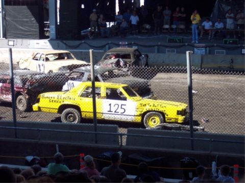 1987 Mercury Grand Marquis - Several cars, including a yellow 1987 Mercury Grand Marquis, compete in a demolition derby event.