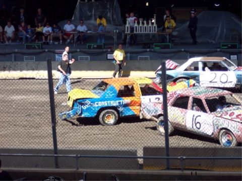 1987 Mercury Grand Marquis - Multiple vehicles are prepared for a demolition derby event, with visible numbers and custom paint jobs.