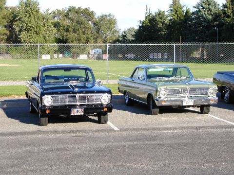 1967 Ford Ranchero - Two Ford Falcons from the mid-1960s are parked in a lot.
