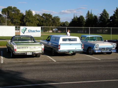 1967 Ford Ranchero - A green 1967 Ford Ranchero is parked next to a blue camper and a light blue and white car.