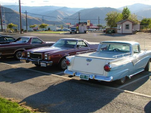 1967 Ford Ranchero - Three Ford Rancheros are parked in a lot with mountains in the background.