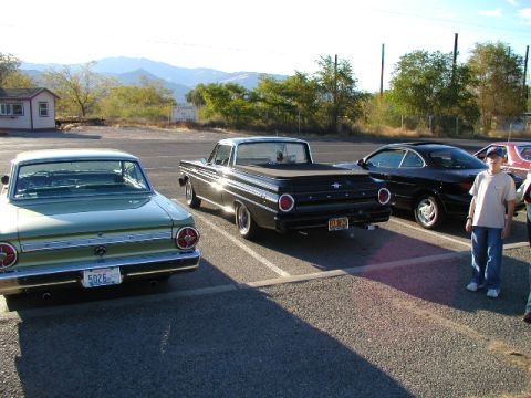 1967 Ford Ranchero - Three classic Ford vehicles are parked in a lot, with a boy standing nearby.