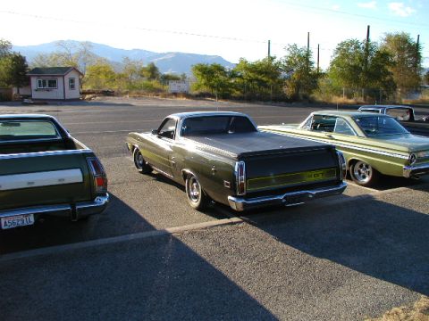 1967 Ford Ranchero - Three vehicles are parked in a lot, with two Ford Rancheros and a classic coupe visible under a bright sky.
