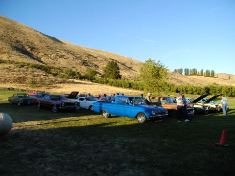 1967 Ford Ranchero - A gathering of classic vehicles on a sunny day with a hill in the background.