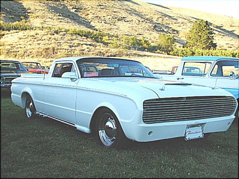 1967 Ford Ranchero - A white 1960 Ford Ranchero pickup truck is seen from a three-quarter front angle, parked outdoors with other vehicles.