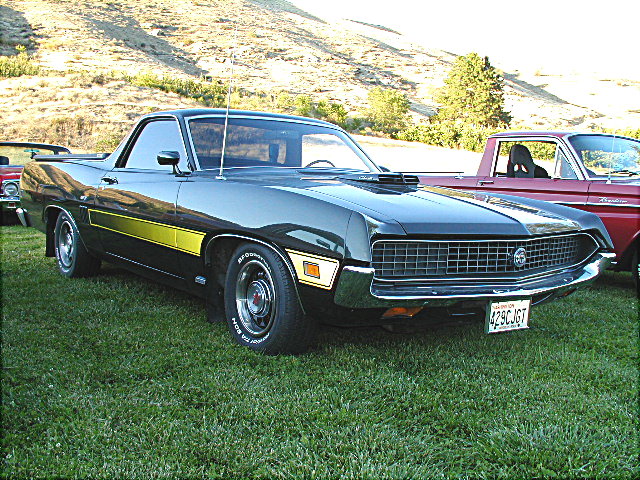 Black Ford Ranchero with yellow stripes, front 3/4 view on grass