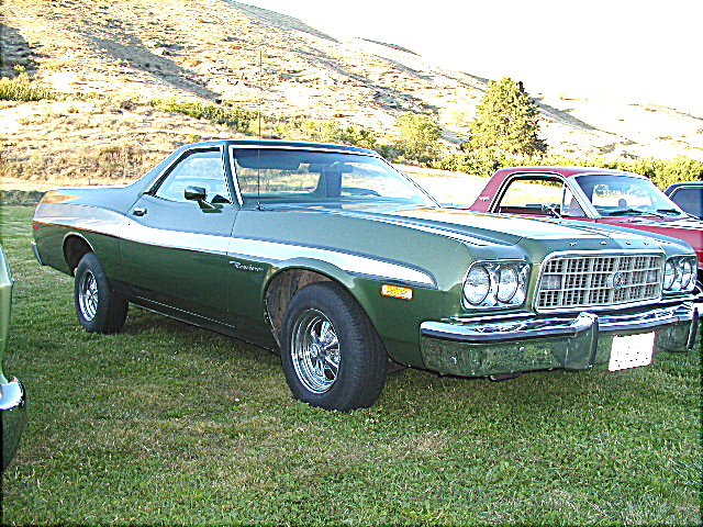 Dark green Ford Ranchero coupe-utility parked on grass, 3/4 front view