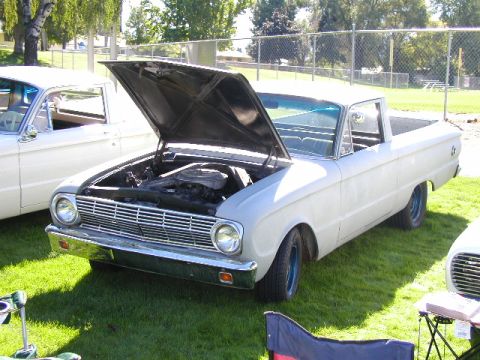 1967 Ford Ranchero - A light-colored Ford Falcon Ranchero is parked on a grassy lawn with its hood open, alongside another vehicle.