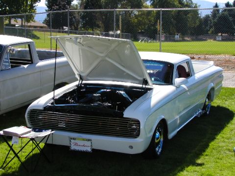 1967 Ford Ranchero - A white 1967 Ford Ranchero is displayed with its hood open, parked on grass next to another pickup truck.