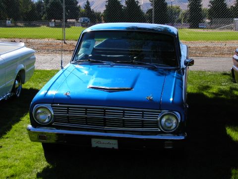 1967 Ford Ranchero - A bright blue 1967 Ford Ranchero is displayed on a grassy field, a prominent chrome grille and a hood scoop.