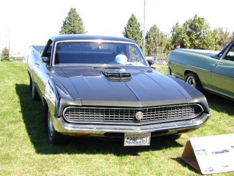 1967 Ford Ranchero - This Ford Ranchero, likely a 1970 model, is parked on a grassy field next to another vehicle.