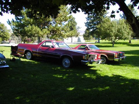 1967 Ford Ranchero - Two Ford Rancheros are parked on a grassy lawn under trees.