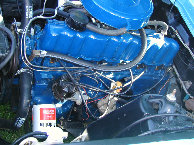 Ford blue engine top view with distributor, plug wires and white Autolite oil filter