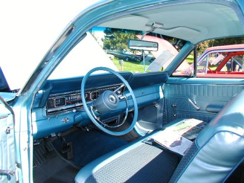 1967 Ford Ranchero - The interior of a blue 1967 Ford Ranchero shows its dashboard and seating. Another vehicle is visible in the background.