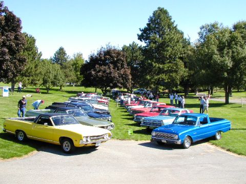 1967 Ford Ranchero - Multiple classic Ford Rancheros are lined up on a sunny day at a car show.